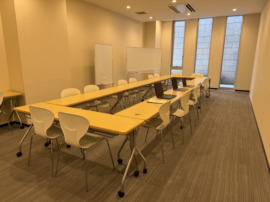 YUA AIスクールの教室風景。品川シーサイドの明るい教室にコの字型テーブルとホワイトボードが設置されている